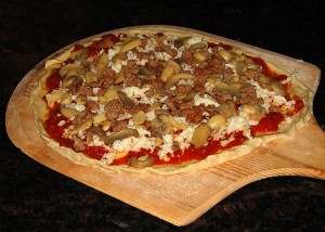 Suasage, Mushroom, Caramelized Onion Pizza ready for oven